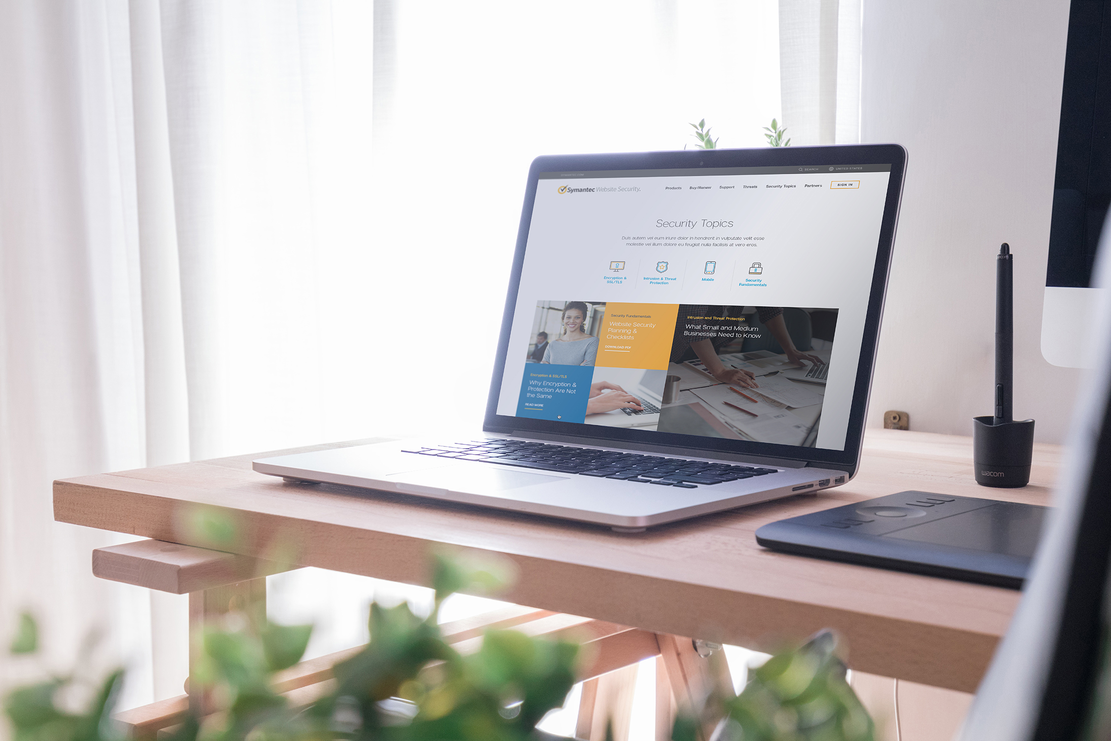 Open laptop sitting on a desk with the Symatec Security Topics web page displayed.